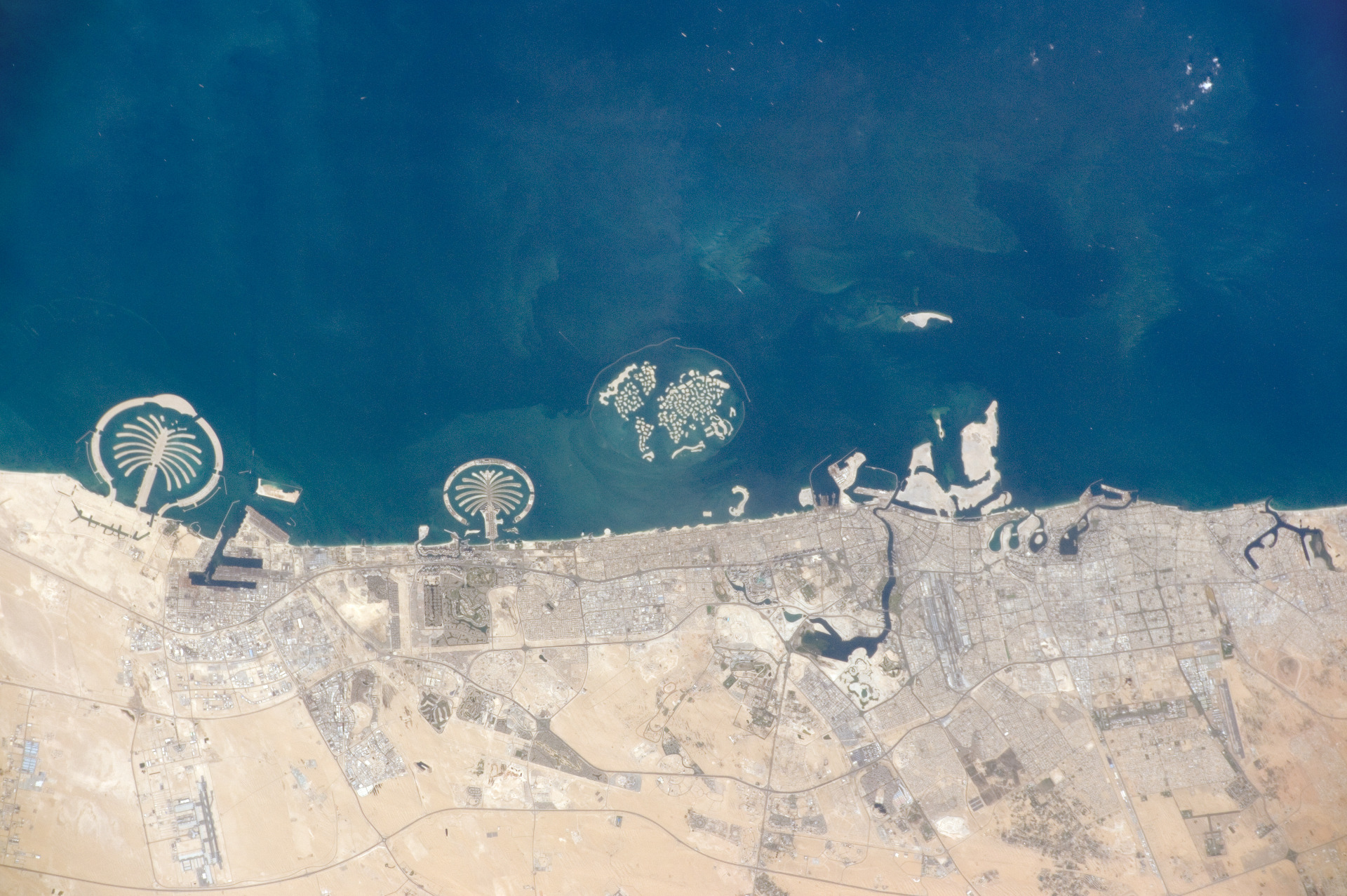 Image satellite des Palm Islands en 2014 avec de gauche à droite Palm Jebel Ali, Palm Jumeirah, The World (ne faisant pas partie du complexe de Palm Islands) et Palm Deira en construction.